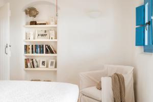 sypialnia z białym łóżkiem i krzesłem w obiekcie Cemilion w Koufonisii
