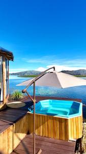a hot tub on a deck with an umbrella at Urus Beluxia in Puno