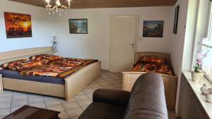- une chambre avec deux lits et un canapé dans l'établissement Ferienwohnung Zauberhaft, à Bad Soden-Salmünster