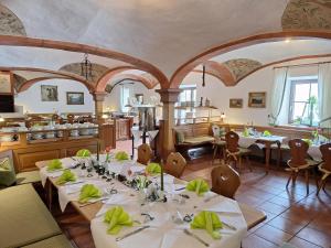 ein Esszimmer mit weißen Tischen und Stühlen in der Unterkunft Karsten Gauselmanns Heißenhof Hotel garni in Inzell