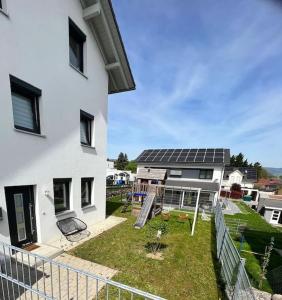 uma casa com um quintal com painéis solares em Ferienwohnung Klettgau-Erzingen em Klettgau