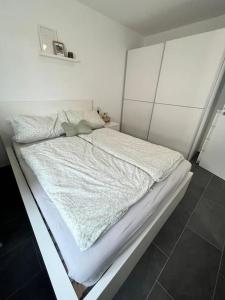 Una cama blanca en una habitación blanca con en Ferienwohnung Klettgau-Erzingen en Klettgau