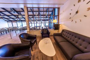 a restaurant with a couch and a table and chairs at The Northern Comfort Inn in Ólafsfjörður