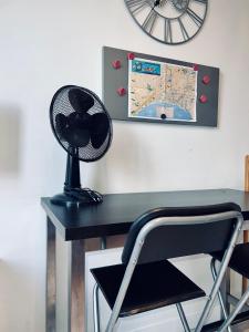 escritorio con ventilador y reloj en la pared en Élégant Studio à 1 minute du centre, en Niza