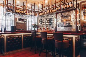 a bar with chairs and a counter with liquor bottles at Purchases Restaurant & Accommodation in Chichester