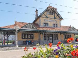 a train station with flowers in front of it at Lovely Acacia in De Haan