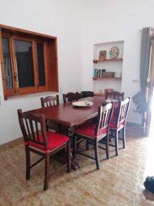 ein Esszimmer mit einem Tisch und 4 Stühlen in der Unterkunft Pine house in Montemesola