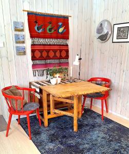 uma sala de jantar com uma mesa de madeira e 2 cadeiras em Berlevåg Apartment em Berlevåg