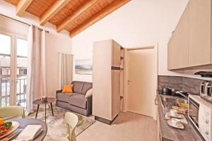 a kitchen and living room with a couch and a table at Corte Fasanella 78 in Toscolano Maderno +9 photos