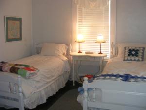 a bedroom with two beds next to a window at PriceHouseInn in Glen Rose