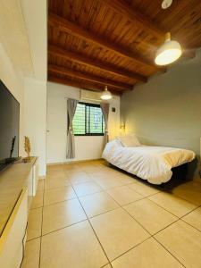 a large bedroom with a bed and a window at El Nido Bombal in Godoy Cruz