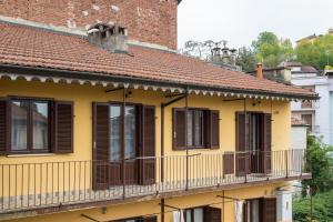 トリノにあるSan Martino sweet homeのバルコニーに茶色のシャッターが付いた黄色い家