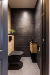 een badkamer met een zwart toilet en een wastafel bij Apartment Viognier in Den Haag