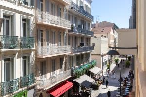 ein Gebäude mit Balkonen und Menschen, die eine Straße hinuntergehen in der Unterkunft Nice 2 Rooms in the heart of Cannes in Cannes