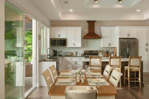 una cocina con mesa y sillas y una cocina con armarios blancos. en Lakeside Lodge with Studio Apartment, en Monticello