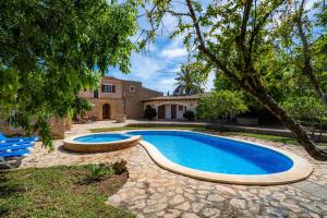 una piscina frente a una casa en Villa Es Pujol den Miquel, en Felanitx