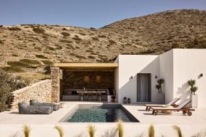 a villa with a swimming pool in front of a mountain at Thea Luxury Villas Ios in Ios Chora