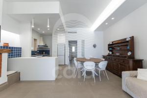 una cucina e un soggiorno con tavolo e sedie di Villa Giulia By Cala Salento a Torre Lapillo Altre 26 foto