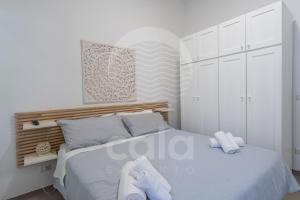 una camera da letto bianca con un letto e asciugamani di Villa Giulia By Cala Salento a Torre Lapillo