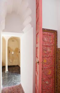 uma porta vermelha num quarto com um chuveiro em P´tit Habibi em Marrakech