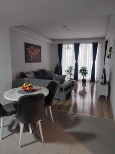 uma sala de estar com uma mesa e um sofá em Skopje Sky City 19th Floor Twin Apartments with Indoor Pool & Spa & Fitness Including in Price em Skopje
