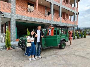 un grupo de personas de pie junto a un jeep verde en Tekoma Resort Cameron Highlands en Tanah Rata