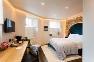 ein Hotelzimmer mit einem Bett und einem Schreibtisch in der Unterkunft Hive Townhouse in Aberaeron