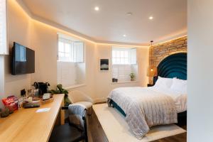 a hotel room with a bed and a desk at Hive Townhouse in Aberaeron