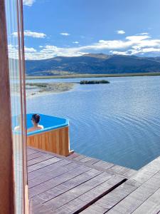 una persona seduta in una vasca da bagno sul lato di un lago di Urus Beluxia a Puno