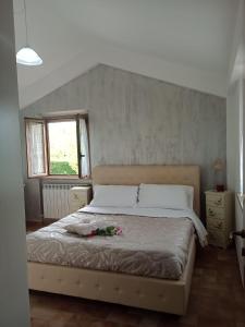 レカナーティにあるCascina del Poetaのベッドルーム1室(花の飾られたベッド1台付)