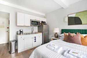 ein Schlafzimmer mit einem Bett und eine Küche mit einem Waschbecken in der Unterkunft 73-919 New Studio UWS Doorman Gym in New York