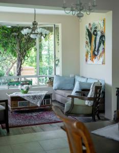 a living room with a couch and a table at Ettys Villa in Giv'at Yo'av