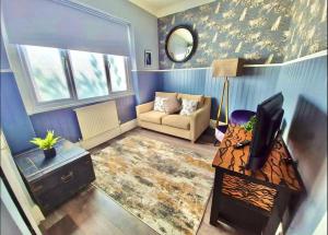 ein Wohnzimmer mit einem Sofa und einem TV in der Unterkunft Blue Cheetah Lemur Lodge in Bournemouth
