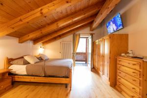 a bedroom with a bed and a flat screen tv at B&B Seppi in Cavalese