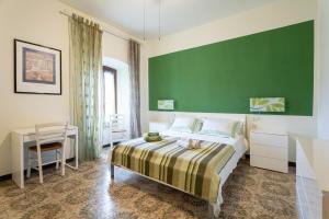 1 dormitorio con cama y pared verde en Locanda San Felice, en San Felice del Benaco