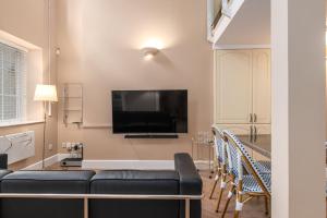 a living room with a couch and a flat screen tv at GuestReady - Beige barley near The British Museum in London