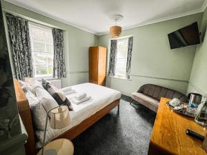 1 dormitorio con cama y sofá en Rock House Hotel, en Lynmouth