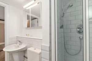 a white bathroom with a sink and a shower at GuestReady - Beige barley near The British Museum in London