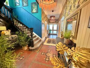 a hallway of a house with plants and a chandelier at Blue Cheetah Lemur Lodge in Bournemouth