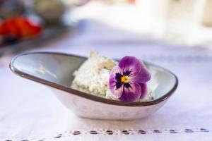 eine Schüssel Essen mit einer lila Blume darin in der Unterkunft Wassererlehen in Bischofswiesen