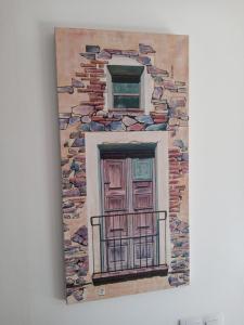 een schilderij van een raam aan een muur bij Com a casa in Falset