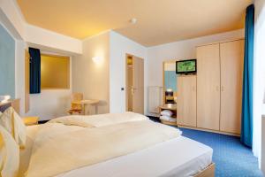 une chambre d'hôtel avec un lit et une télévision dans l'établissement Good Life Hotel Zirm, à Obereggen