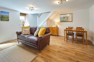 a living room with a couch and a table at Host & Stay - Rose Cottage in Thropton