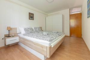 um quarto com uma cama e piso em madeira em BH ROSE Apartment em Ljubljana