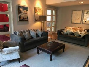 uma sala de estar com dois sofás e uma mesa em Wimbledon Tennis House with Hot Tub; 4 minute walk em Londres