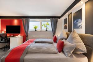 a bedroom with a large bed with red walls and a desk at Apartment Am Tobelbach in Unterlenningen