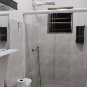 a bathroom with a shower with a glass door at Acomodações Casa 2 in Cananéia
