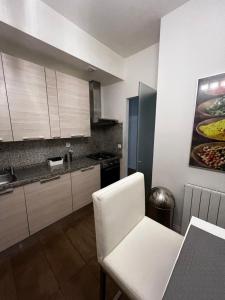 eine Küche mit weißen Schränken, einem Tisch und einem weißen Stuhl in der Unterkunft Four reasons apartment in Prag