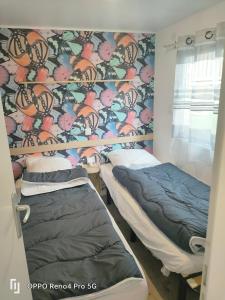 2 lits dans une chambre d'hôpital avec papier peint dans l'établissement Camping Soleiluna, à Rocbaron