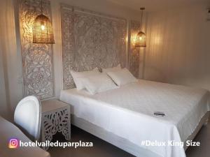 a bedroom with a large bed with a white bedspread at Hotel Valledupar Plaza in Valledupar